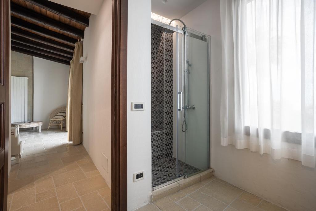 La salle de bains est pourvue d'une douche à l'italienne et d'une porte en verre. dans l'établissement Villa a 300 Mt. dal Mare (Magaggiari) con campo da tennis, à Cinisi