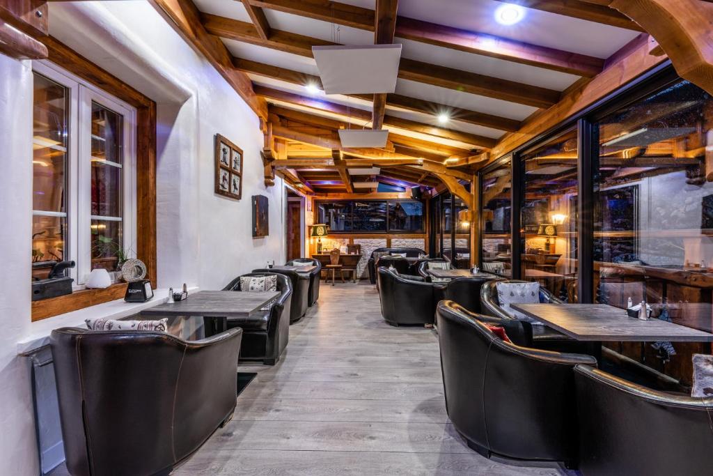 une rangée de tables et de chaises dans un restaurant dans l'établissement Logis Hôtel et Spa Le Christiania, à La Salle Les Alpes