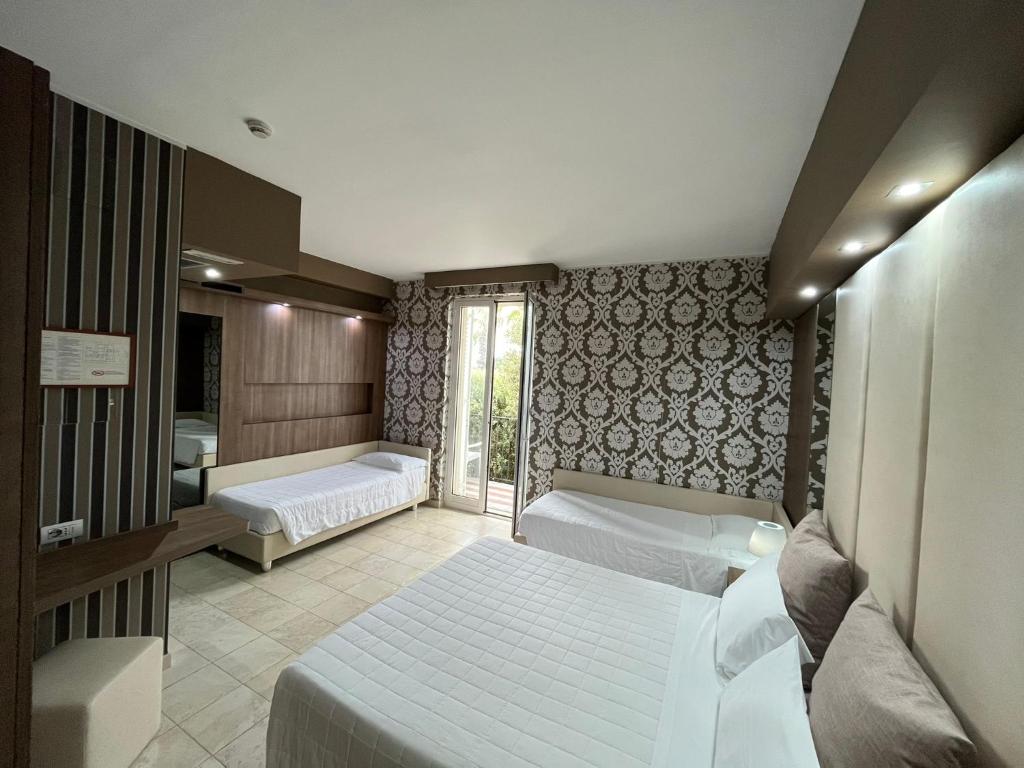 une chambre avec deux lits et une fenêtre dans l'établissement Hotel Lafayette, à Giovinazzo