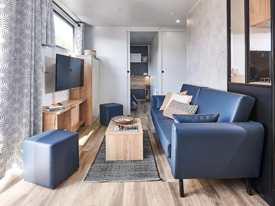 un salon avec un canapé bleu et une télévision dans l'établissement Modèle d'exception, 3 ch, 2 sdb, 43m2 - proche parc aquatique, à Lattes