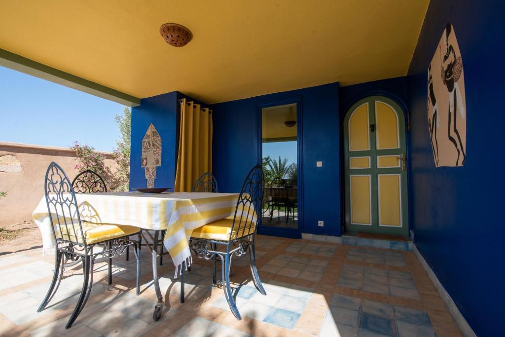 une salle à manger avec des murs bleus et une table et des chaises dans l'établissement L’oasis de kima, à Taroudant
