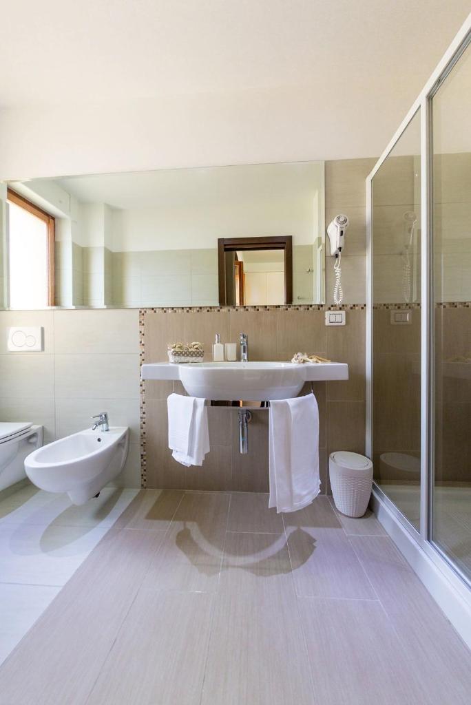 une salle de bain avec un lavabo, des toilettes et une douche dans l'établissement Hotel Vittoria, à Vasto