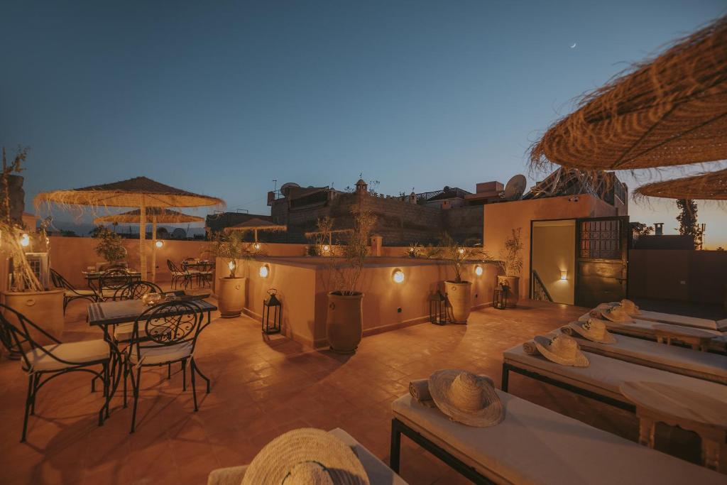 un patio avec des chaises, des tables et des parasols dans l'établissement Riad l'Esprit des Patios & Spa, à Marrakech