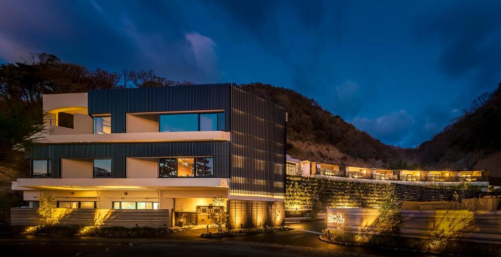 un bâtiment avec des lumières en face d'une montagne dans l'établissement Mayu Futahari, à Nishiizu