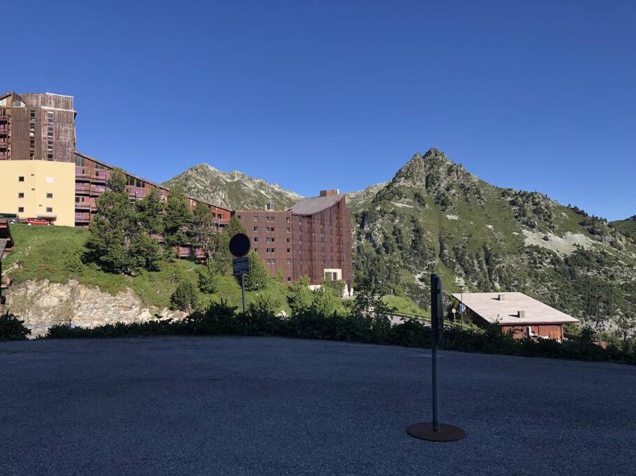 un panneau de rue devant un bâtiment et une montagne dans l'établissement Appartement La Marmotte, Arc 2000, à Bourg-Saint-Maurice