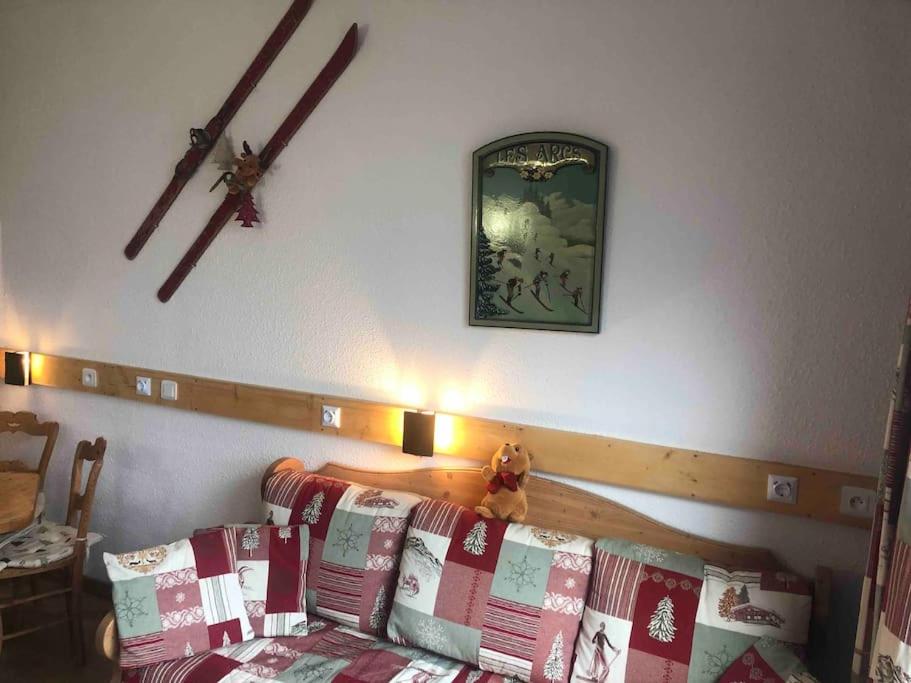 un lit avec un ours en peluche assis dessus dans l'établissement Appartement La Marmotte, Arc 2000, à Bourg-Saint-Maurice