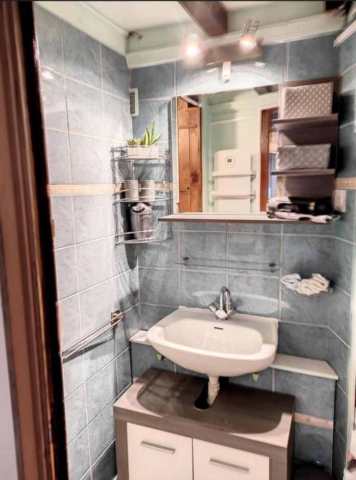 une salle de bain avec un lavabo et un miroir dans l'établissement Refuge de l'Ecureuil, à Métabief