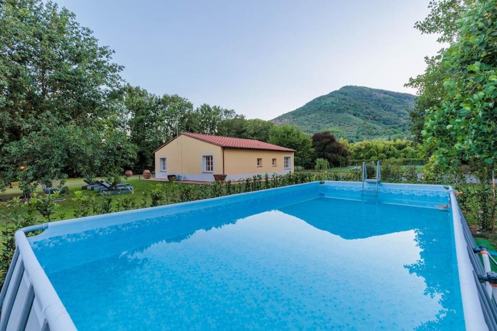 une piscine devant une maison dans l'établissement Villa Bassotta, a Charming Cottage, à Lucques