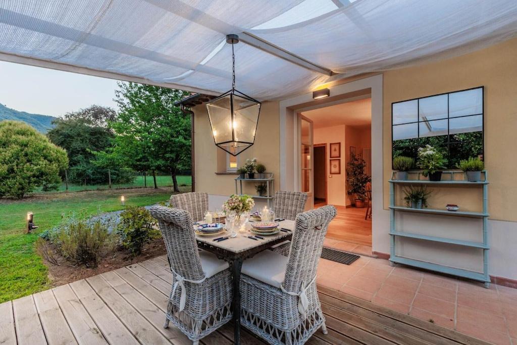 une salle à manger avec une table et des chaises sur un patio dans l'établissement Villa Bassotta, a Charming Cottage, à Lucques