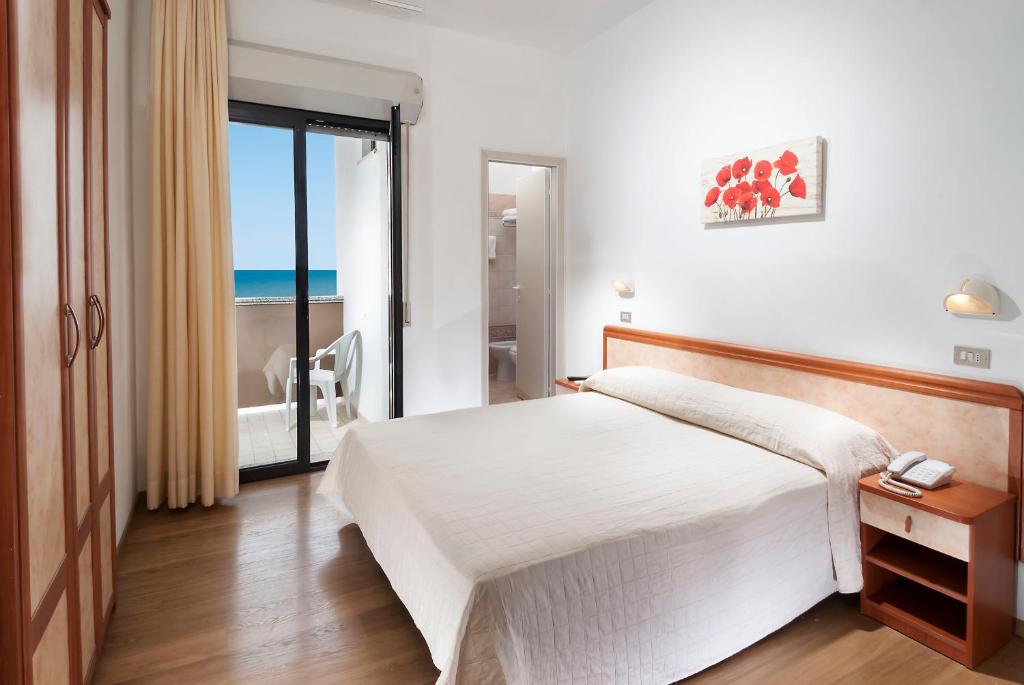 une chambre avec un lit et une vue sur l'océan dans l'établissement Hotel Olympic, à Misano Adriatico