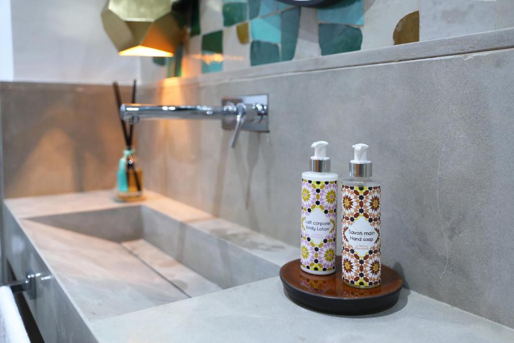 Deux bouteilles d'odorisants assises sur un comptoir dans une salle de bains dans l'établissement RIAD THE MILESTONE, à Marrakech