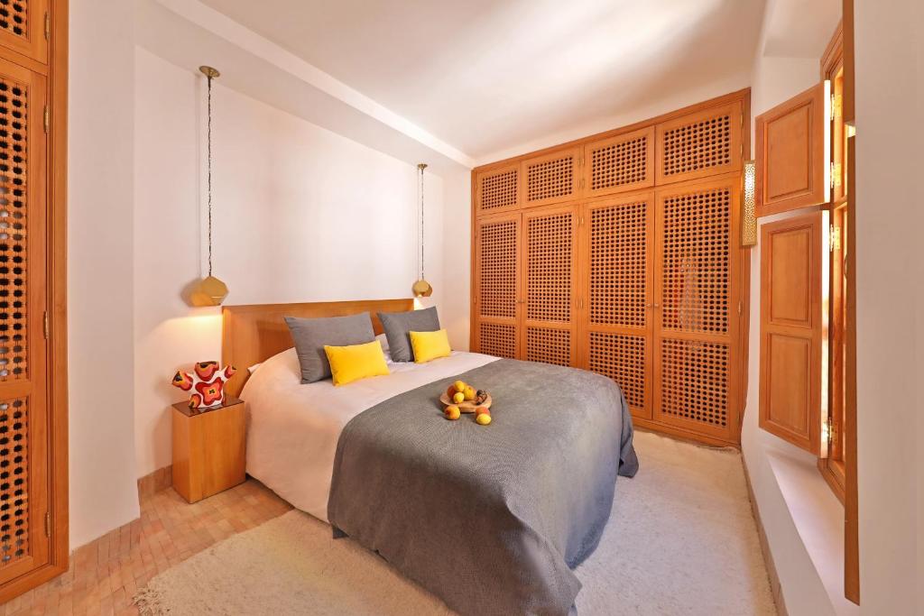 - une chambre avec un lit doté d'oreillers jaunes et bleus dans l'établissement RIAD THE MILESTONE, à Marrakech