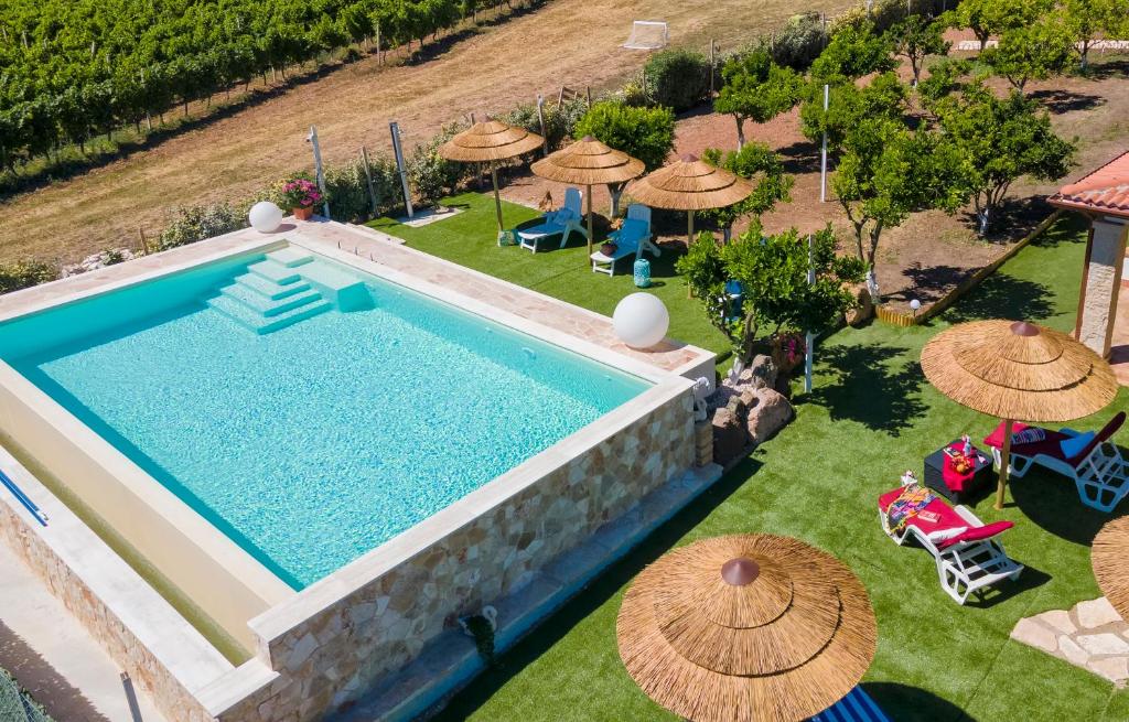 une vue aérienne d'une piscine avec des parasols dans l'établissement Residenza alla Collina & Romantic SPA, à Porto Conte