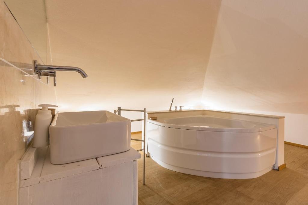 La salle de bains est pourvue d'une grande baignoire blanche et d'un lavabo. dans l'établissement Villa Rogaro Corinna, à Griante Cadenabbia