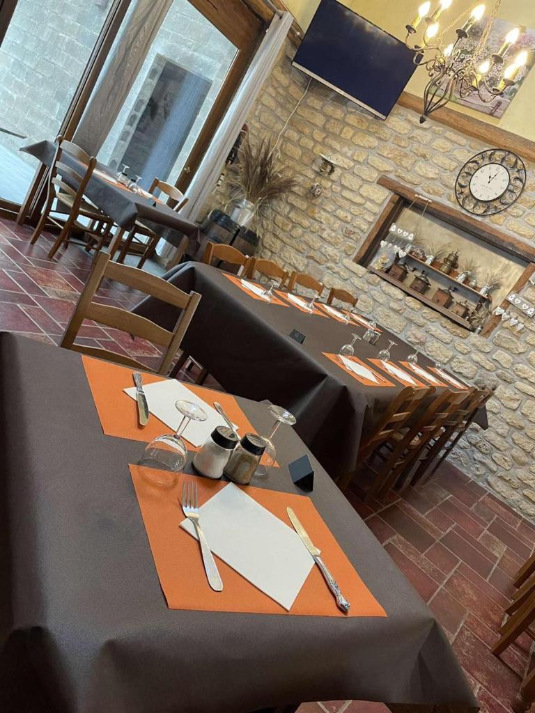 une salle à manger avec des tables et des chaises et une horloge dans l'établissement Kota à la ferme, à Beaumont-en-Argonne 23 autres photos
