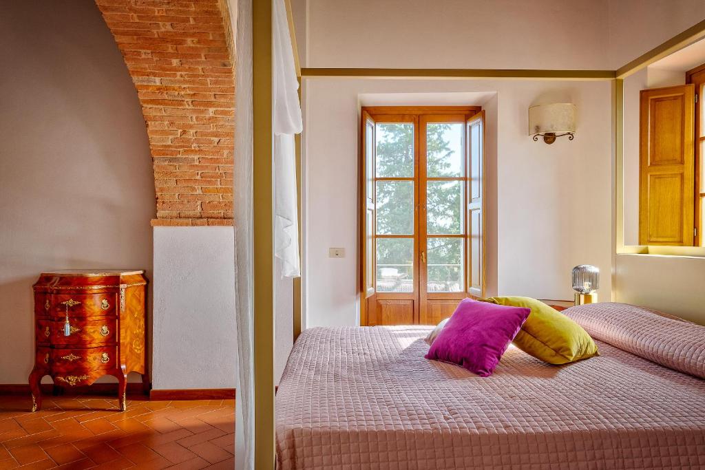 - une chambre avec un lit doté d'oreillers violets et jaunes dans l'établissement Villa Maria, à Monte San Savino