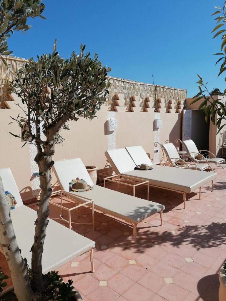 - une rangée de tables et de chaises blanches sur la terrasse dans l'établissement DAR MAR'OUKA , Maison d'hôtes, à Marrakech 27 autres photos