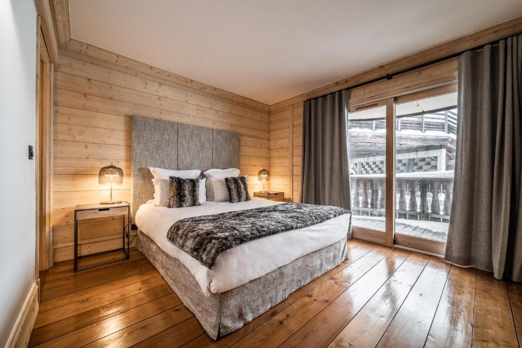 une chambre avec un lit et une grande fenêtre dans l'établissement Les Balcons de Pralong Courchevel 1850 - by EMERALD STAY, à Courchevel