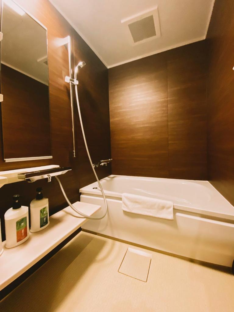 une salle de bain avec une baignoire et un lavabo dans l'établissement Ryokan Sawaya Honten, à Kyoto