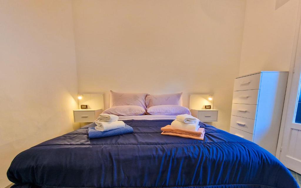 une chambre avec un lit bleu avec des serviettes dessus dans l'établissement ASHUR310 RESIDENCE MONDELLO, à Mondello