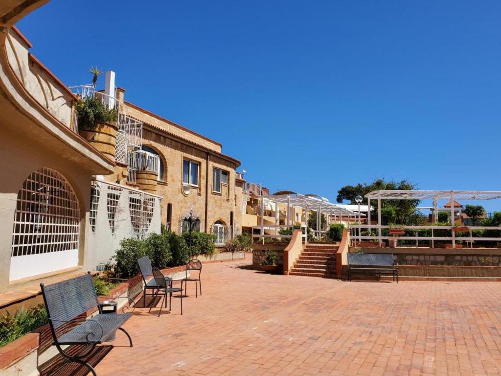 - un ensemble de chaises assises sur une terrasse en briques dans l'établissement ASHUR310 RESIDENCE MONDELLO, à Mondello