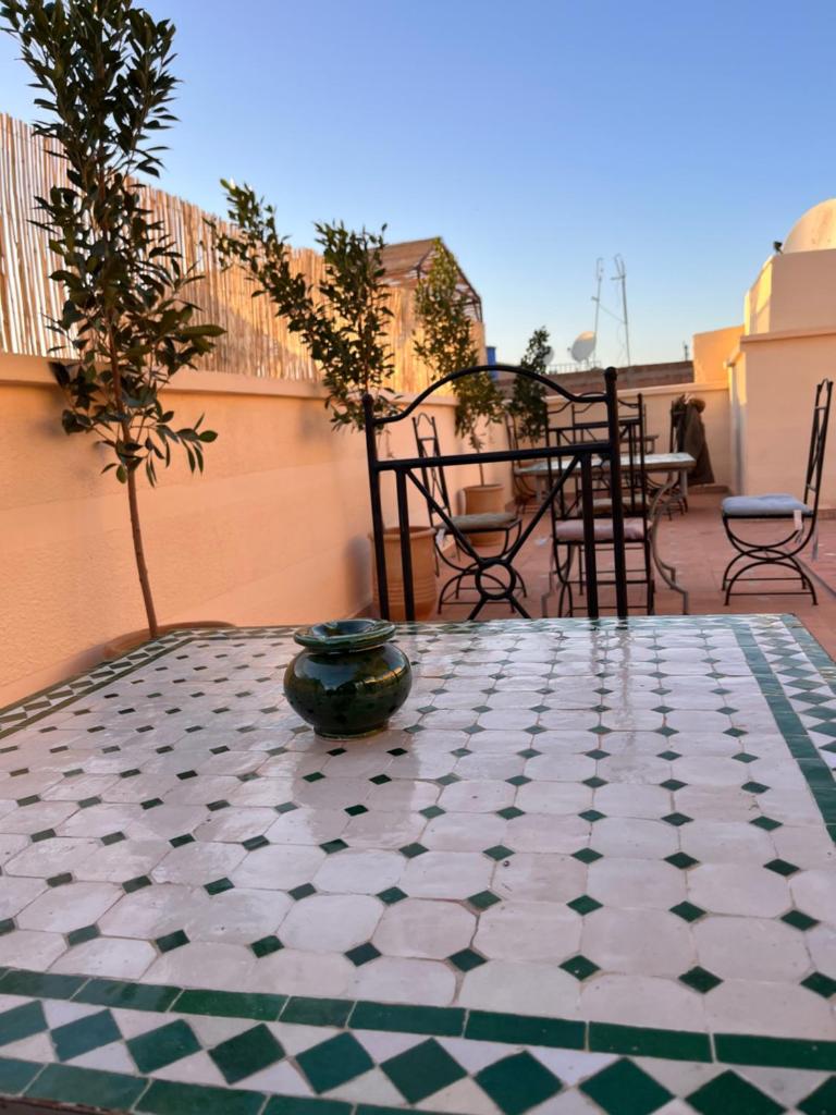 - une terrasse avec une table et du carrelage dans l'établissement Riad Black Doors, à Marrakech