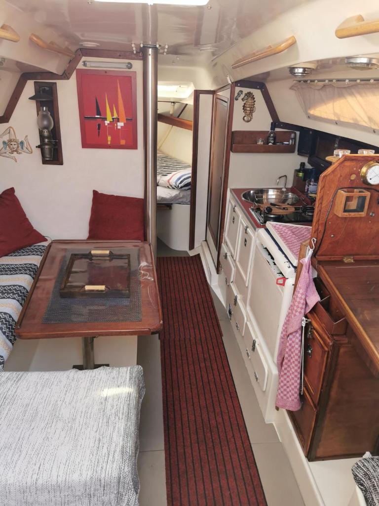 - une petite cuisine avec une table et une cuisinière dans l'établissement stlocavoile 2, Seuls à bord d un voilier, à Porto-Vecchio
