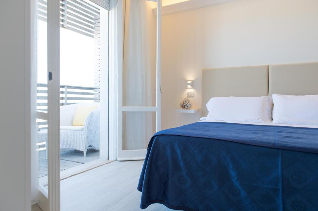 une chambre avec un lit avec une couette bleue dans l'établissement Kiss Beachfront Hotel & Restaurant, à Cervia