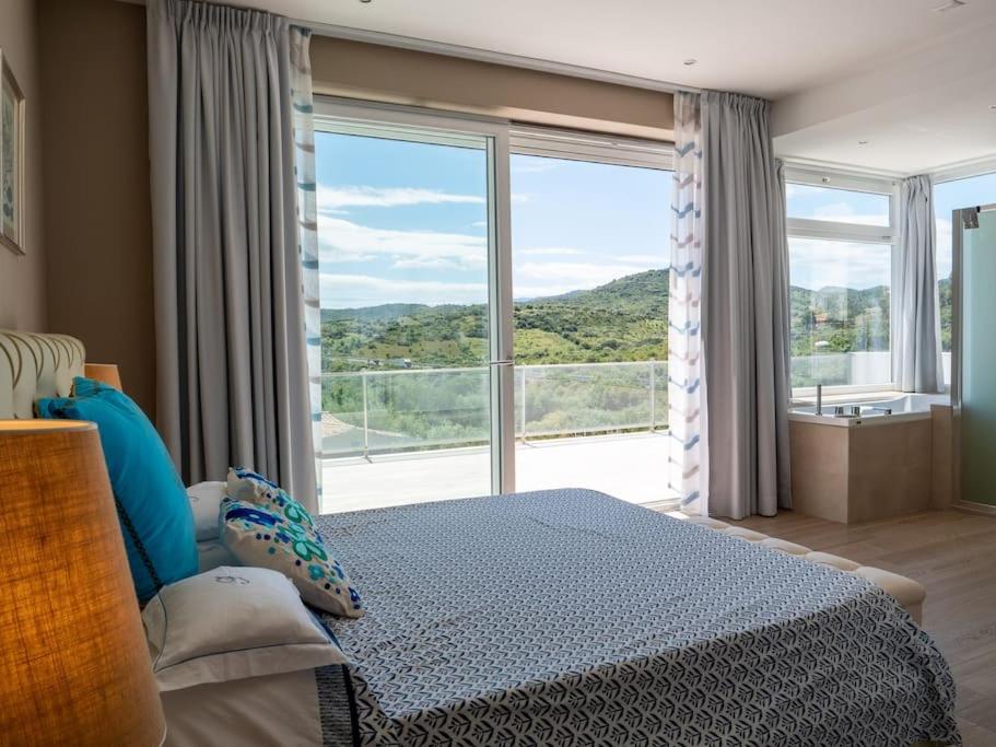 une chambre avec un lit et une grande fenêtre dans l'établissement Villa con piscina privata BudoniAffitti, à Budoni