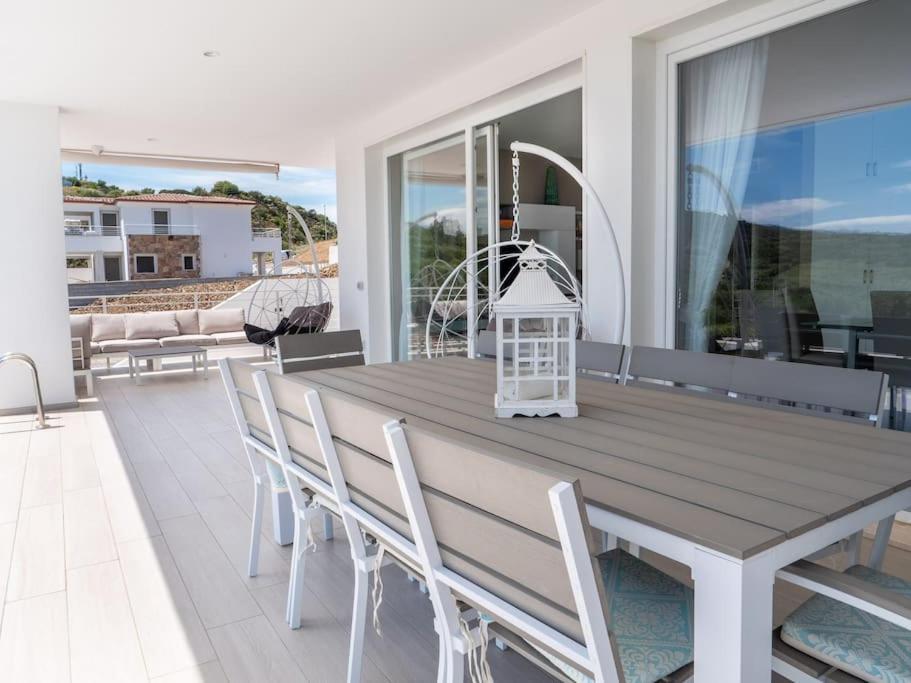une table et des chaises sur une terrasse avec vue sur l'océan dans l'établissement Villa con piscina privata BudoniAffitti, à Budoni