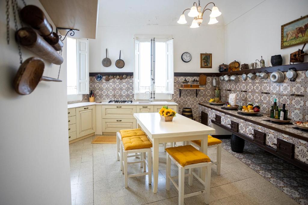 une cuisine avec une table blanche et deux tabourets dans l'établissement Antica Fortezza Villa Fontana, à Valderice