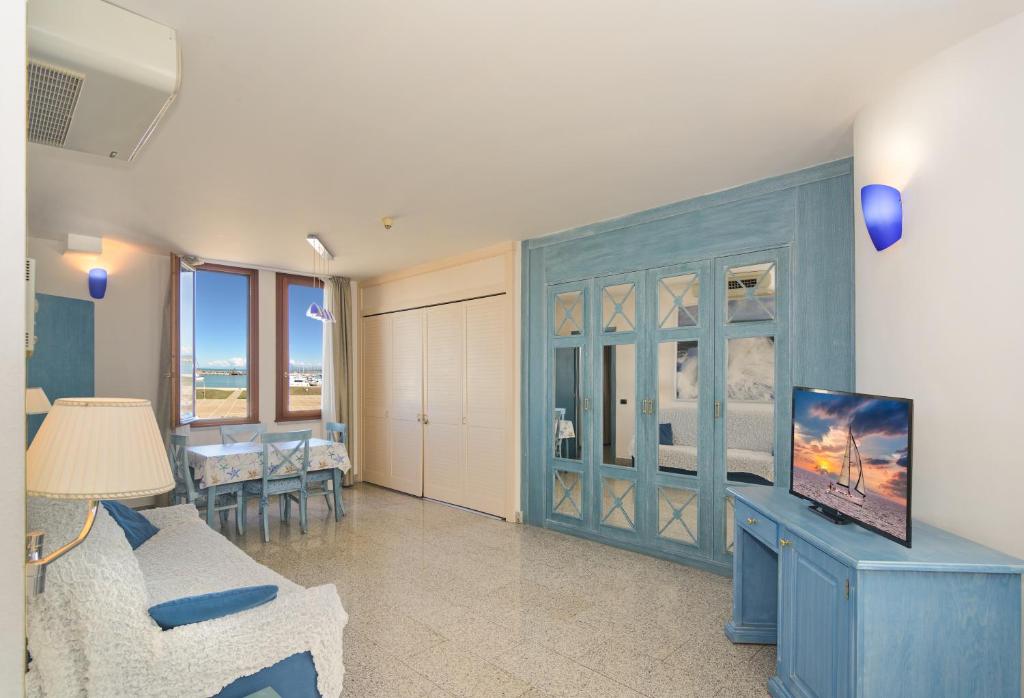 un salon avec une armoire bleue et une télévision dans l'établissement Residence Hotel L'incanto Di Boccadarno, à Marina di Pisa