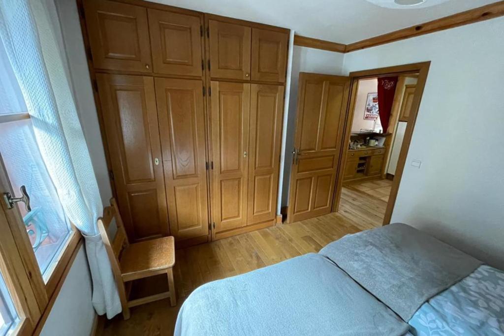 - une petite chambre avec un lit et des placards en bois dans l'établissement Large apartment in Chamonix - close to the slopes, à Chamonix-Mont-Blanc 2 autres photos