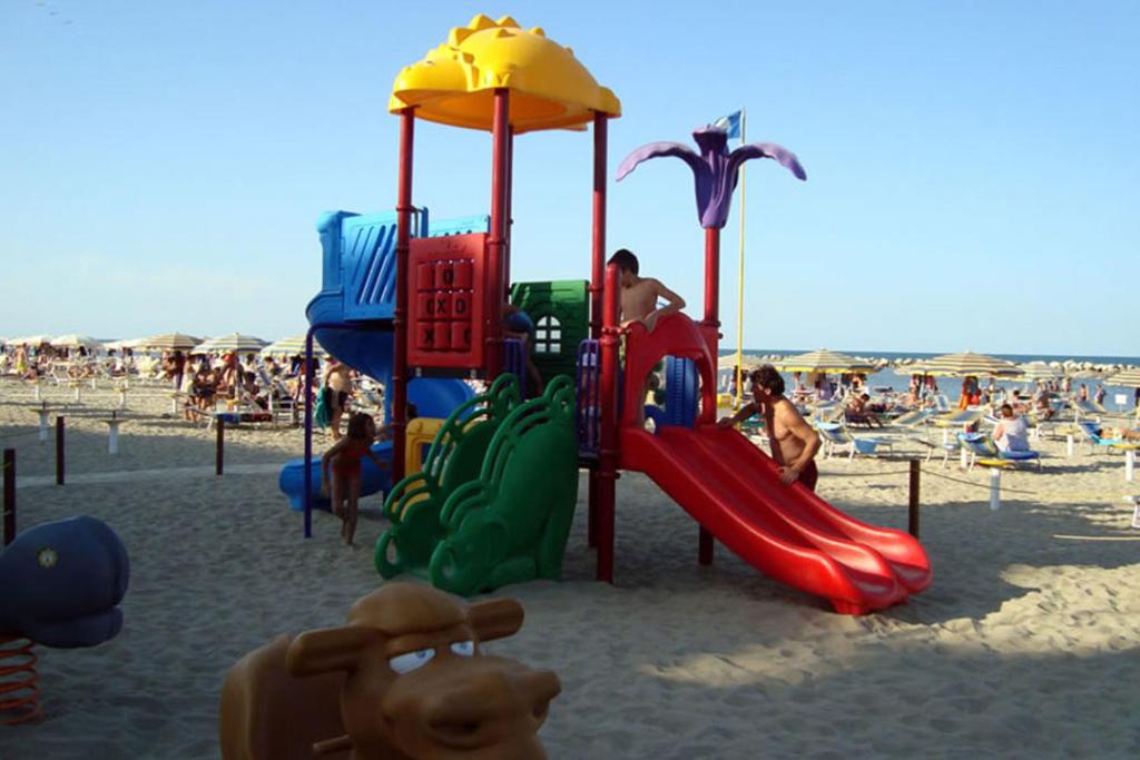 - une aire de jeux sur la plage avec des personnes sur le sable dans l'établissement Hotel Residence Fausta, à Bellaria-Igea Marina