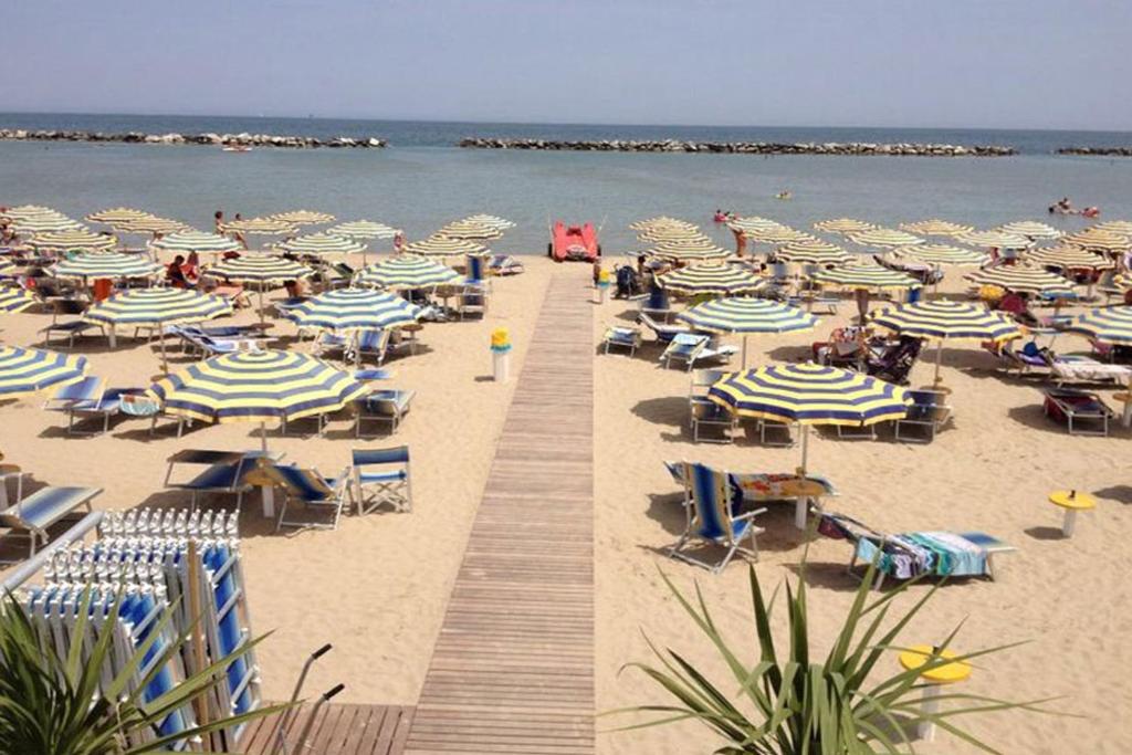 - une plage avec un bouquet de chaises et de parasols dans l'établissement Hotel Residence Fausta, à Bellaria-Igea Marina