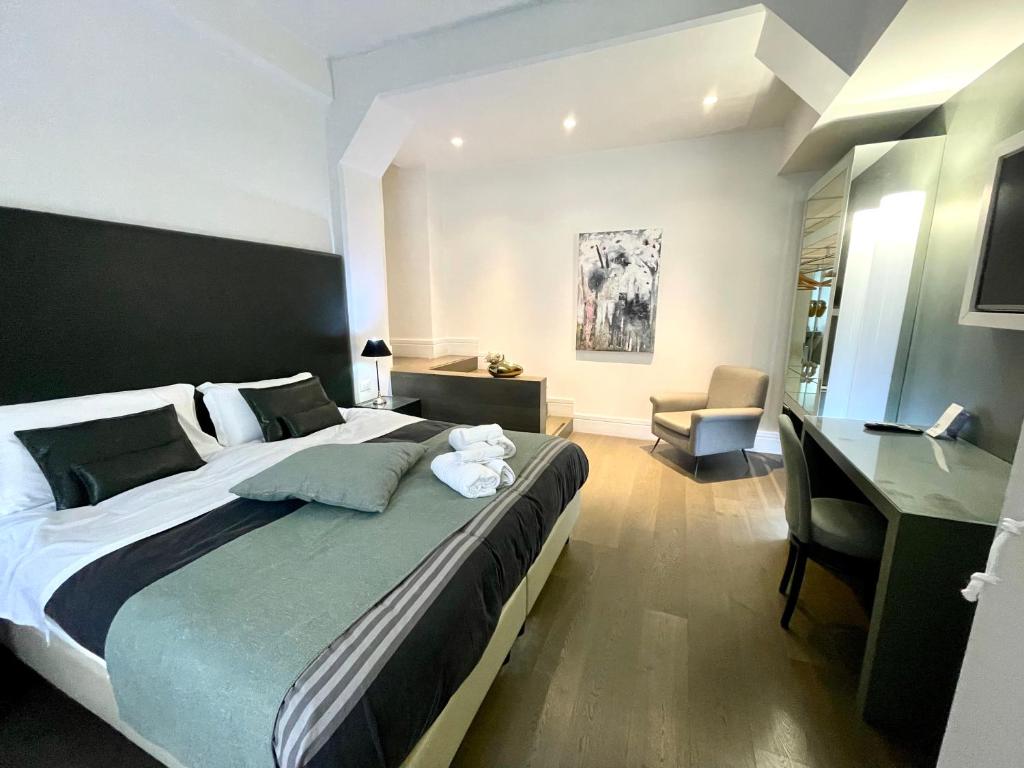 une chambre avec un grand lit et un bureau dans l'établissement XENIA LUXURY ROOMS, à Reggio de Calabre