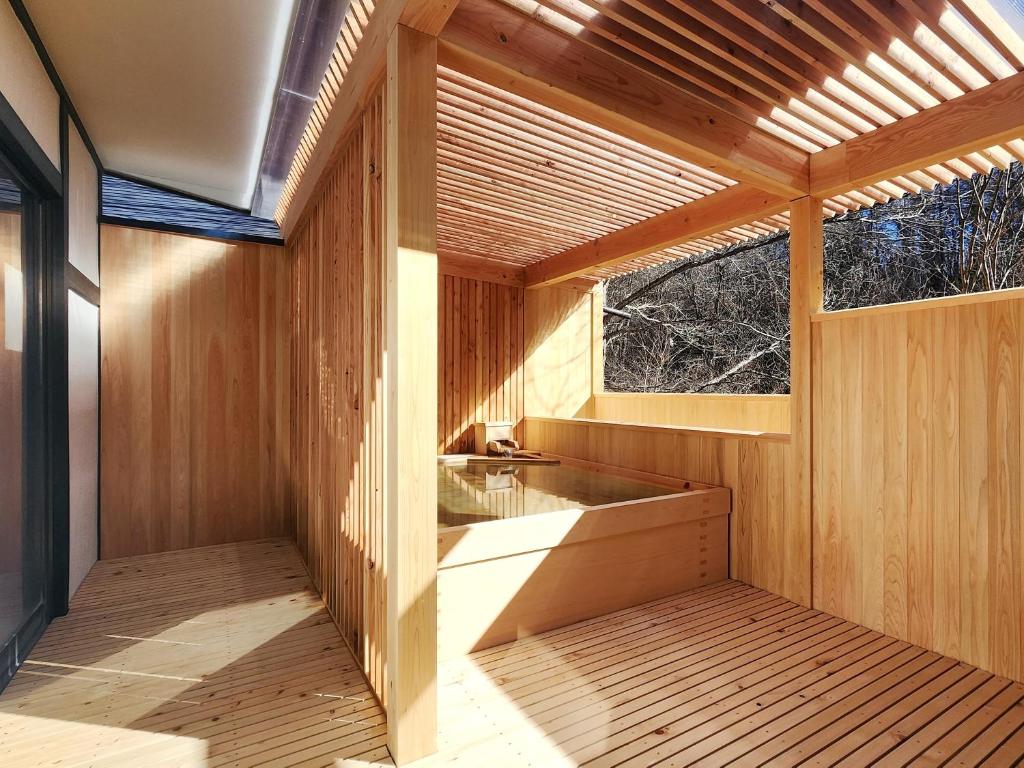 - un sauna en bois avec un lavabo et 2 fenêtres dans l'établissement Kose Onsen, à Karuizawa
