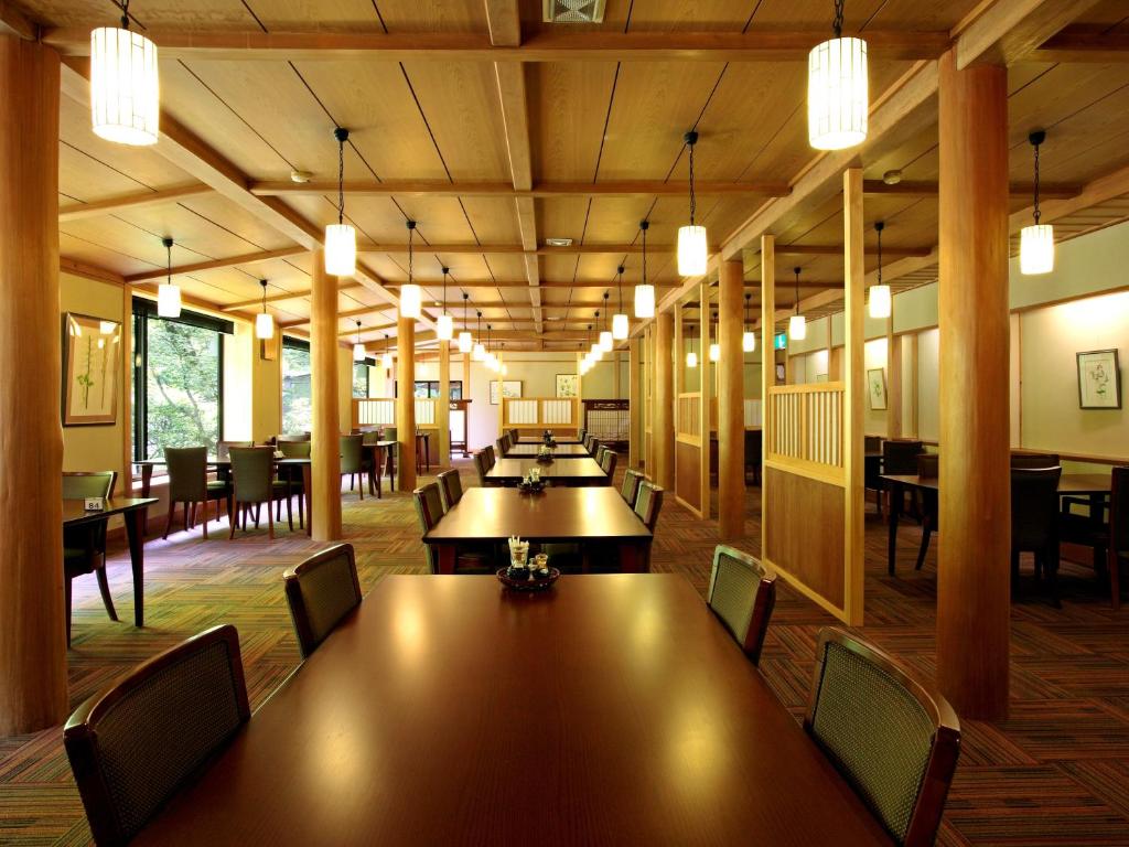une salle de conférence avec des tables, des chaises et des lumières dans l'établissement Kose Onsen, à Karuizawa