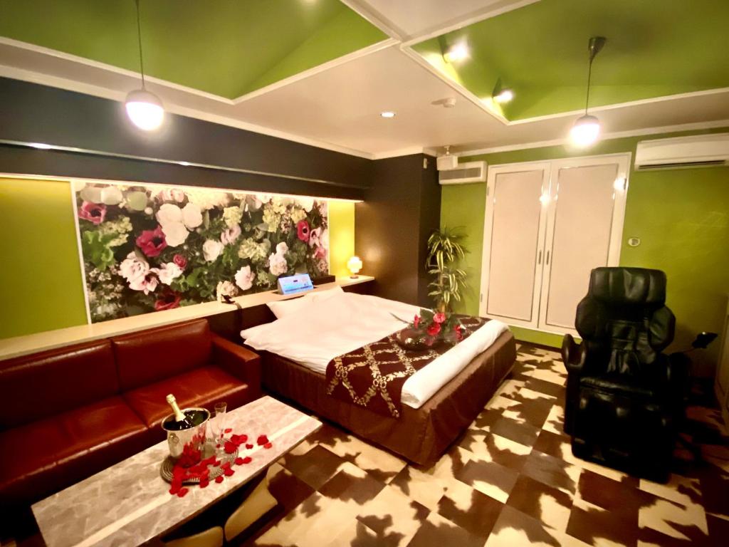 une chambre avec un lit et un canapé dans l'établissement ホテル南の風風力3駒ヶ根店, à Komagane