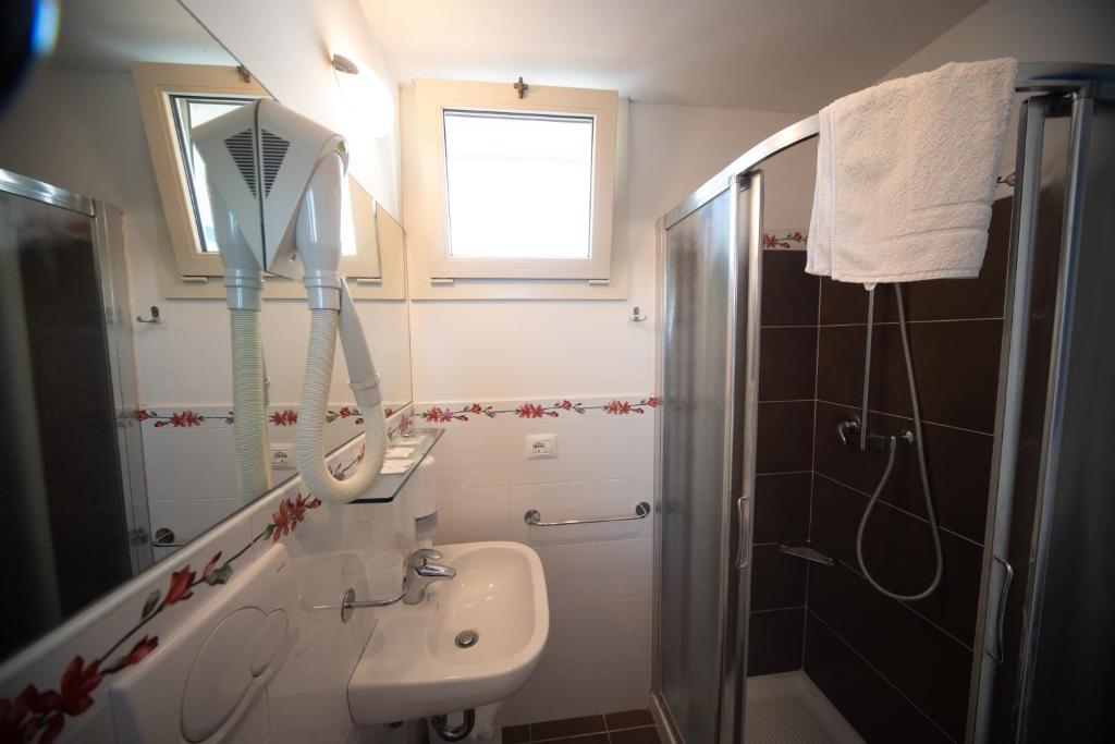 une salle de bain avec un lavabo et une douche avec un miroir dans l'établissement Hotel Alabama, à Riccione 26 autres photos