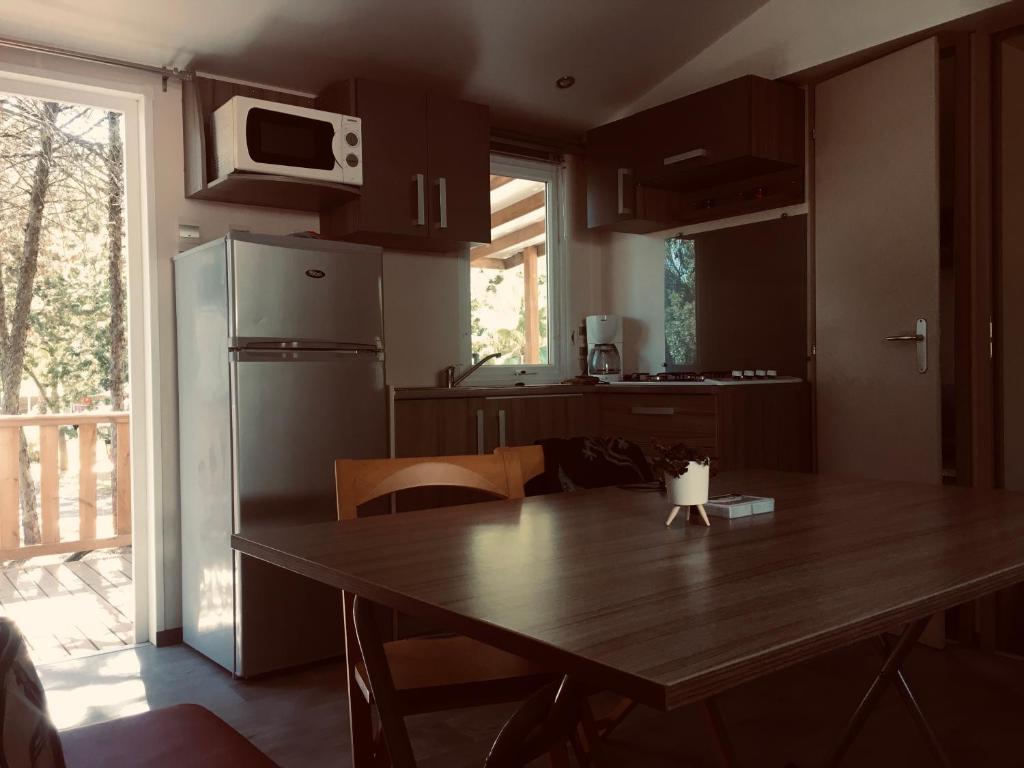 une cuisine avec une table en bois et un réfrigérateur dans l'établissement parc des 7 fonts, à Agde