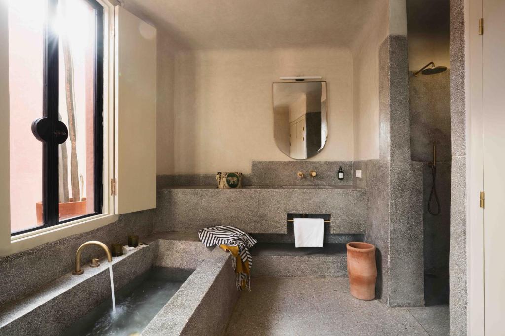 une salle de bain avec un lavabo et un miroir dans l'établissement Maison Brummell Majorelle, à Marrakech