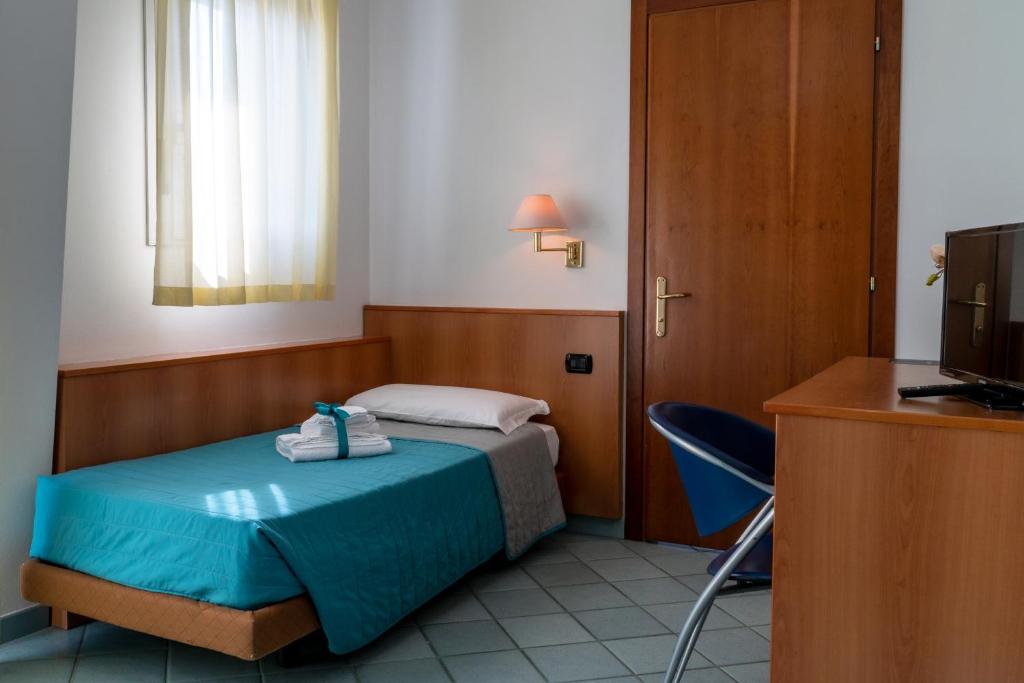 une chambre avec un lit, un bureau et une télévision dans l'établissement Hotel Alisei, à Lignano Sabbiadoro 41 autres photos