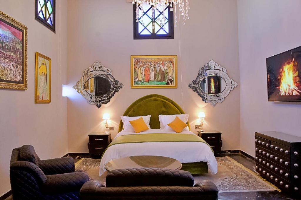 une chambre avec un grand lit et deux chaises dans l'établissement Dar Chrifa, à Rabat