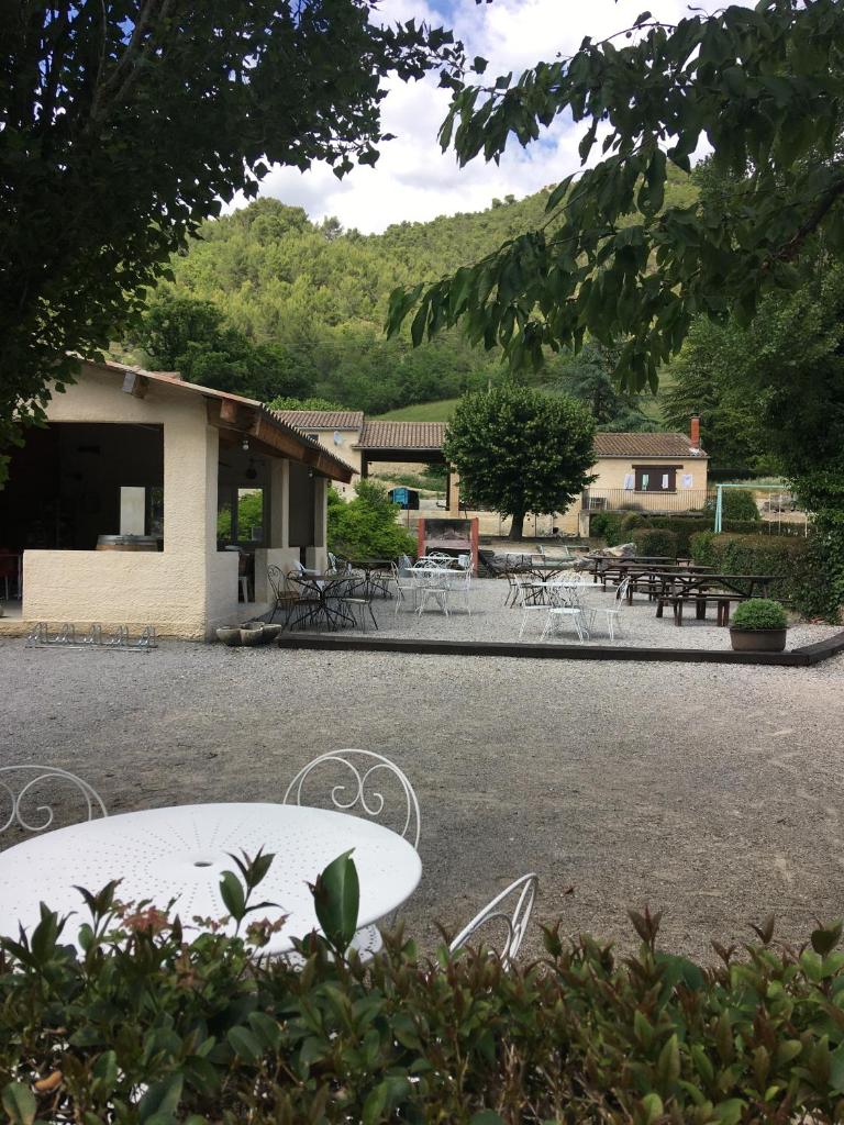 une table et des chaises devant un bâtiment dans l'établissement Camping le Chambron, à Condorcet 1 autre photo