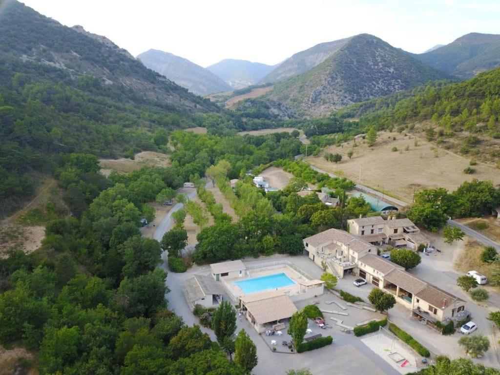 - une vue aérienne sur une maison avec une piscine et des montagnes dans l'établissement Camping le Chambron, à Condorcet