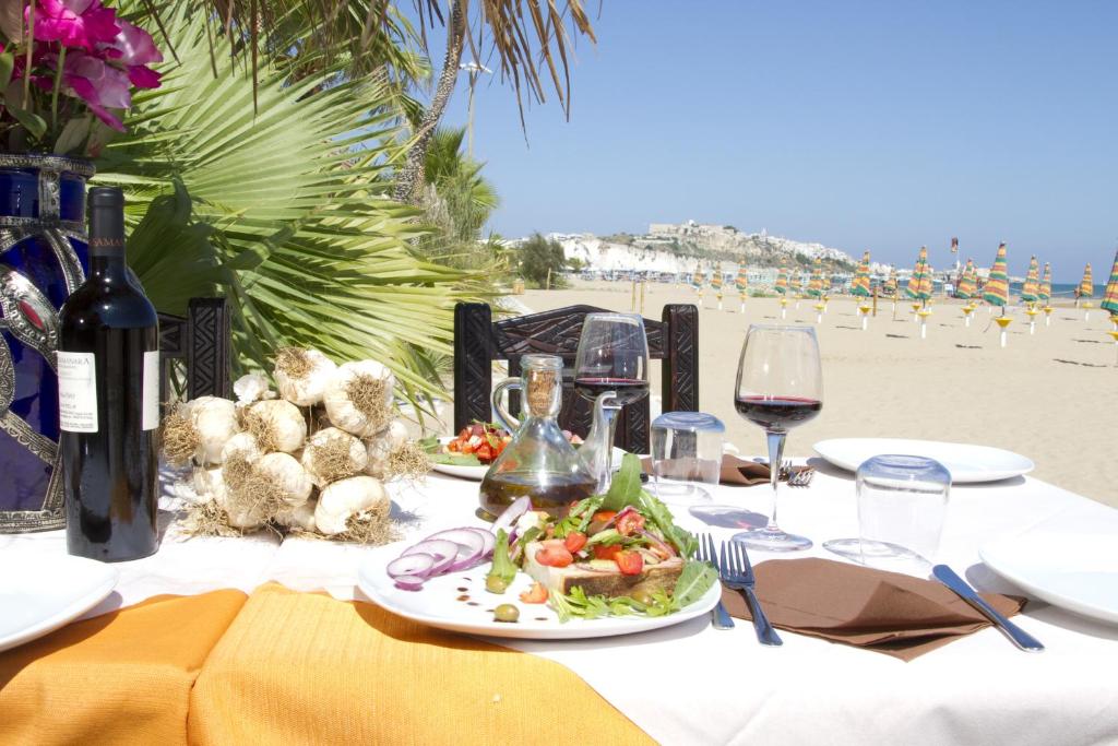 - une table avec une assiette de nourriture et de vin sur la plage dans l'établissement Oasi Beach Hotel, à Vieste 29 autres photos
