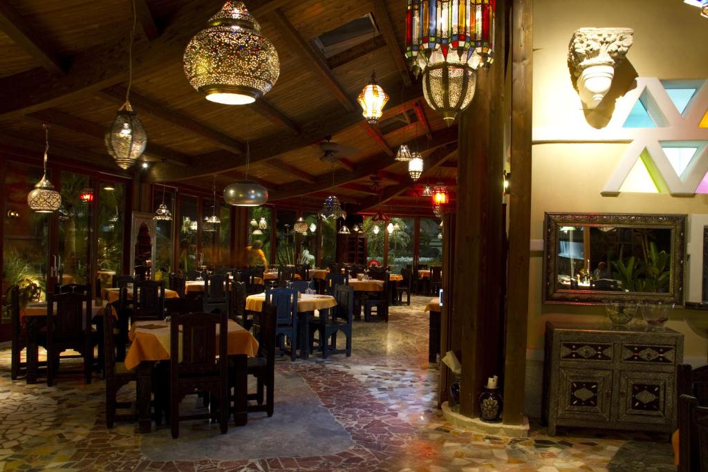 une salle à manger avec tables, chaises et lustres dans l'établissement Oasi Beach Hotel, à Vieste
