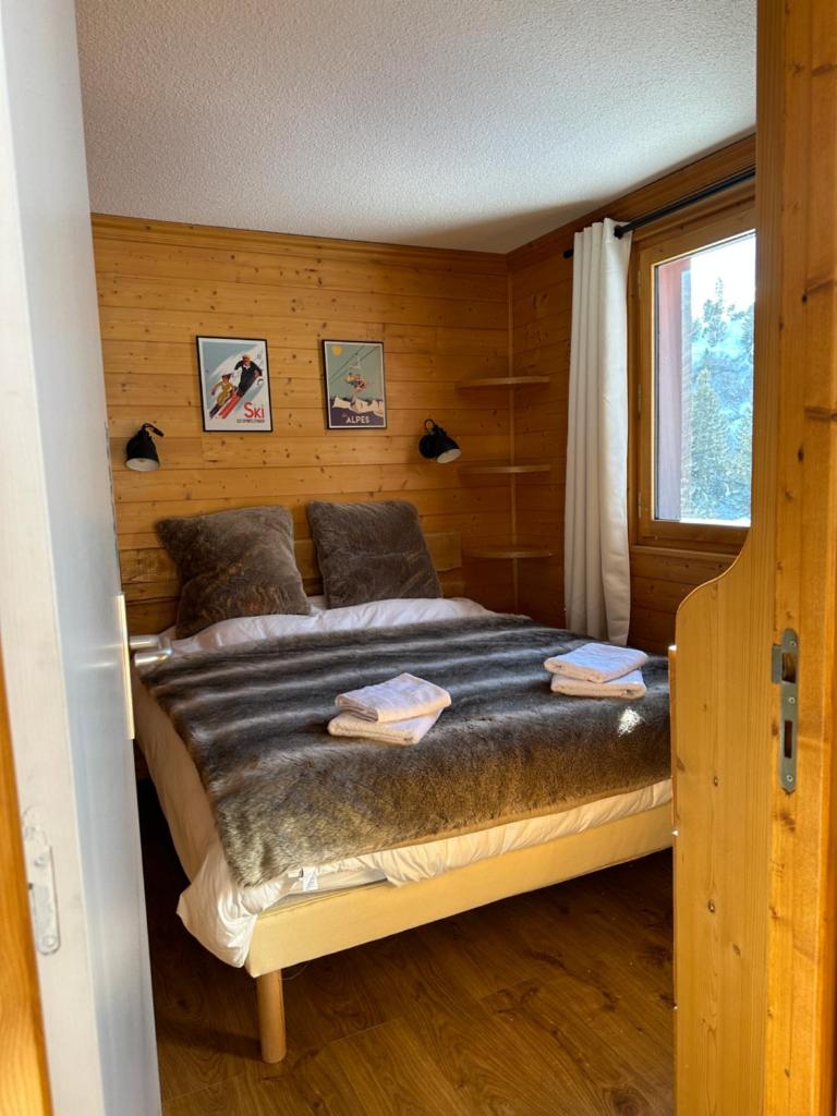 une chambre avec un lit dans une pièce en bois dans l'établissement Duplex - Plein sud - Pied des pistes - 50m2 - Mottaret, à Les Allues