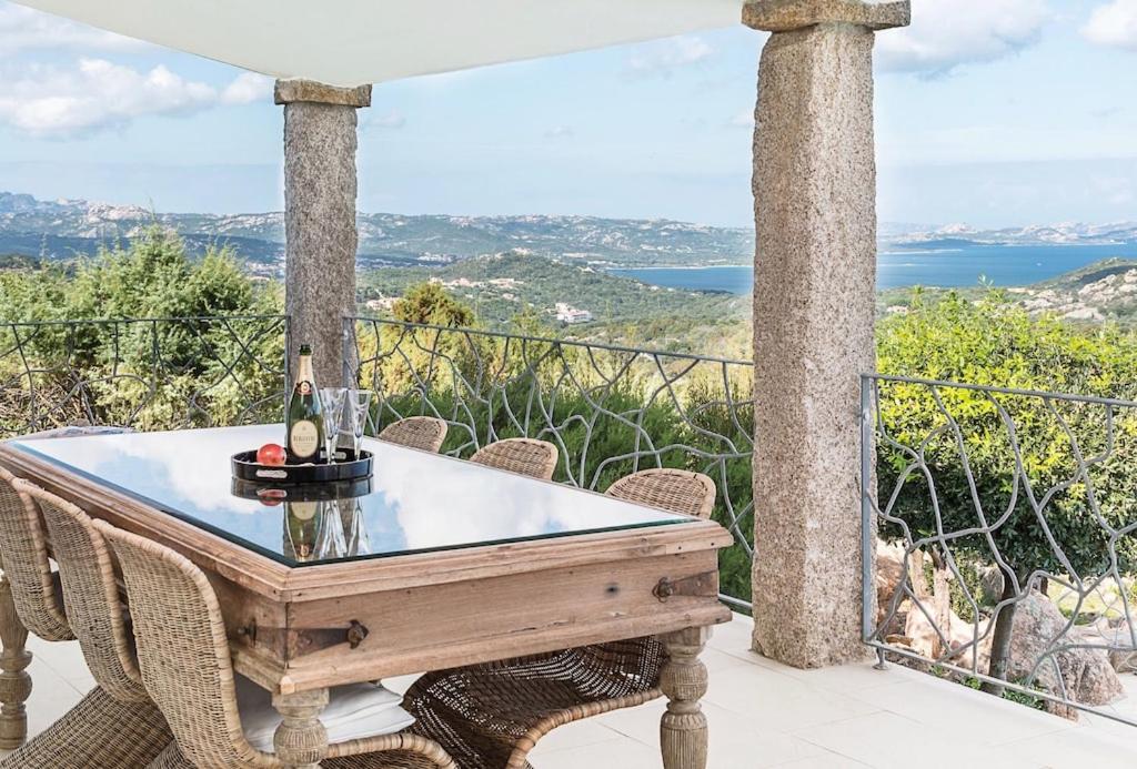 - une table avec une bouteille de vin sur le balcon dans l'établissement Smeralda Oasis, à Arzachena